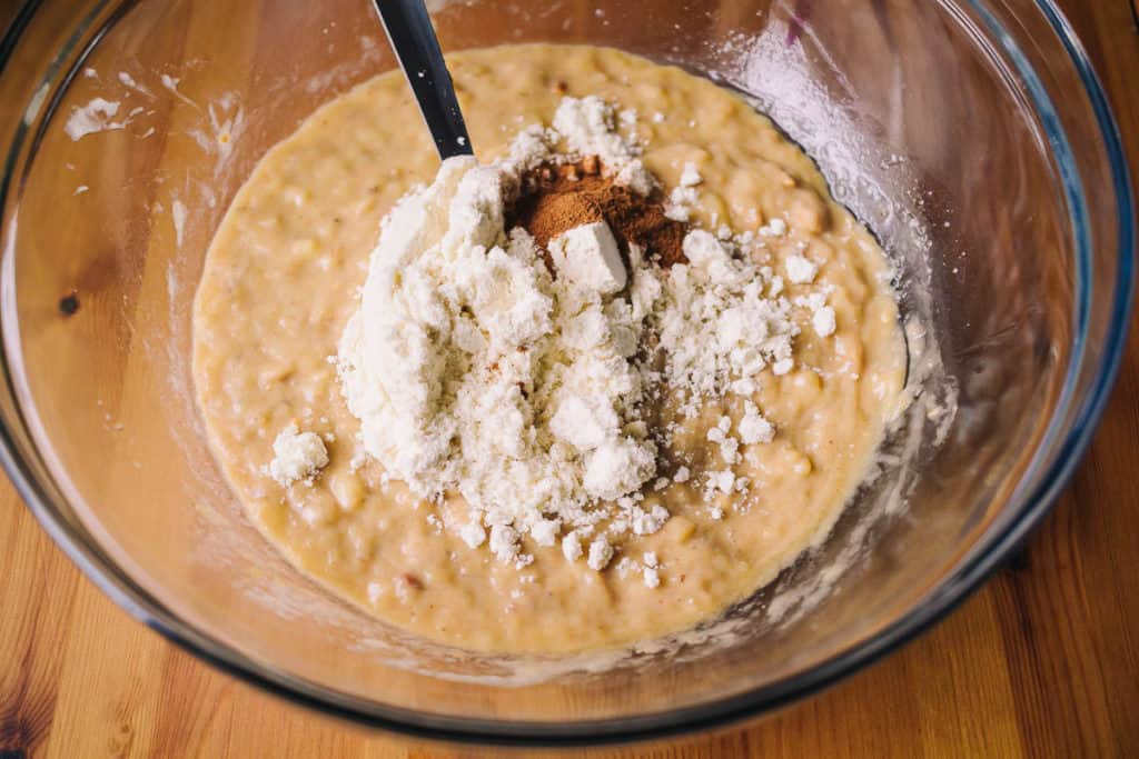 Glass bowl of banana muffins batter with whey protein and cinnamon
