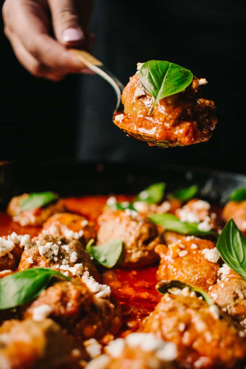 spoonful of lamb meatballs over a cast iron skillet