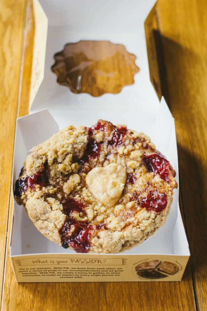 Mini Cherry Crumb Pie on a wooden table with a heart shape in the middle of the pie at grand traverse pie company