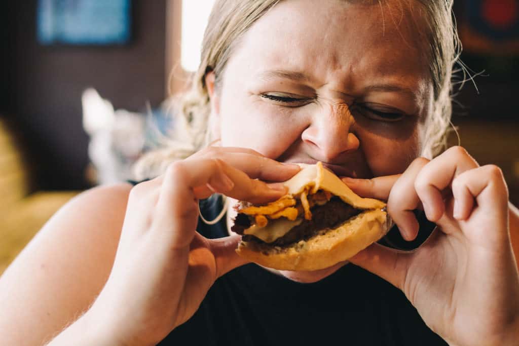 girl biting into a burger at Bubba's