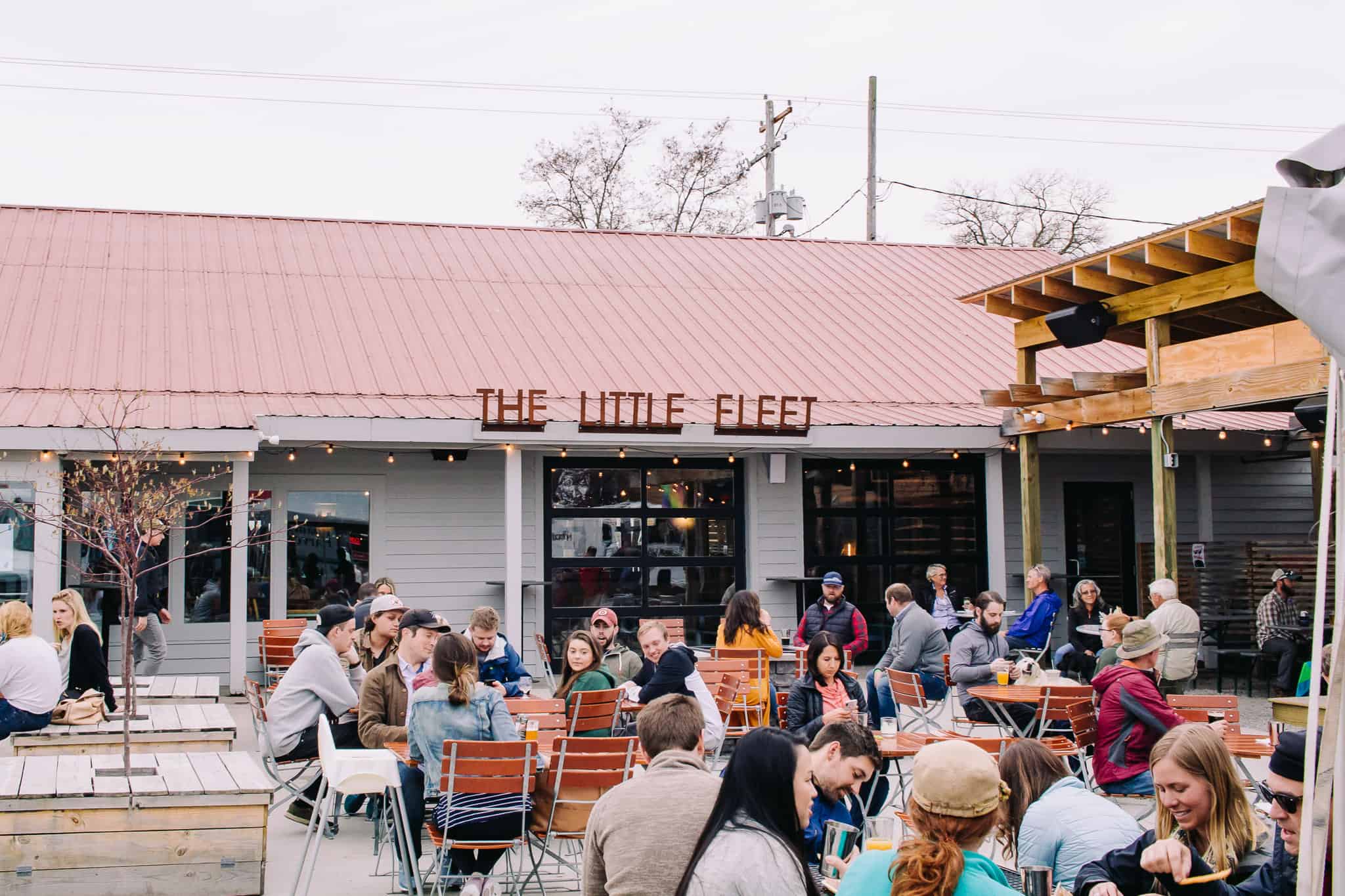 lots of people sitting outside on the patio at the little fleet