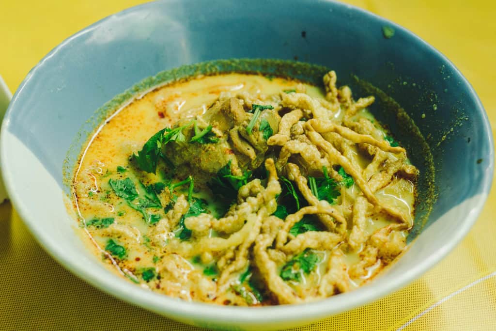 bowl of khao soi with crispy egg noodles