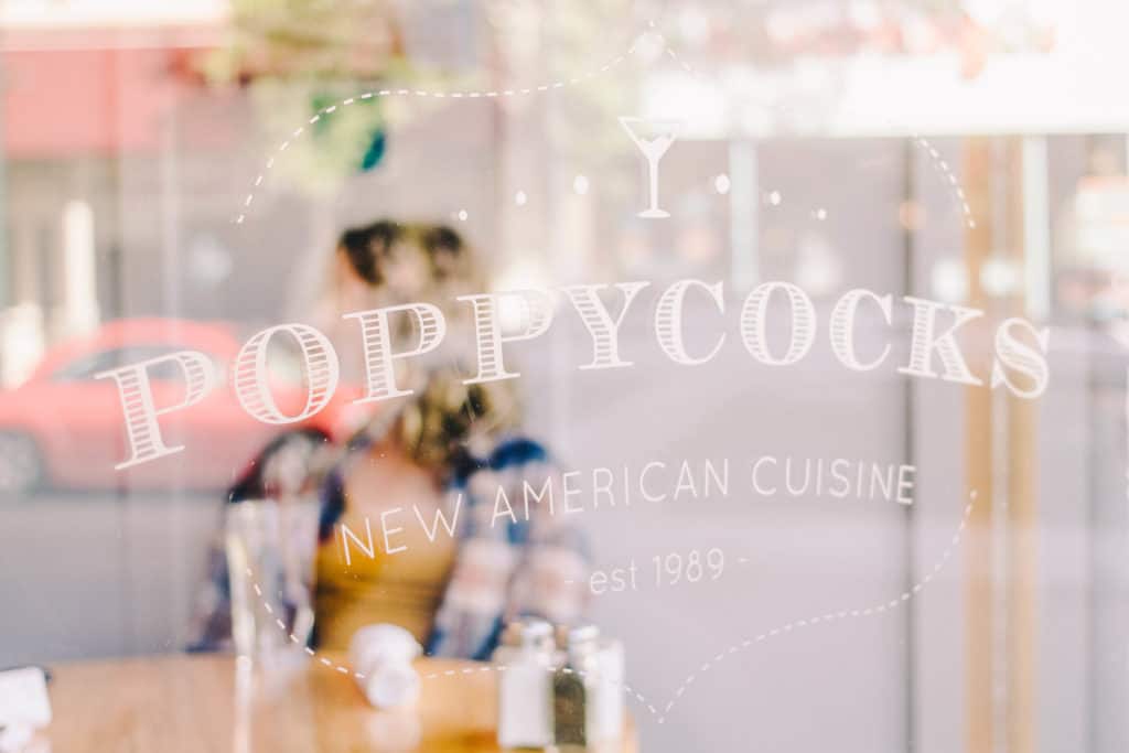 girl sitting inside of poppycocks restaurant at a table