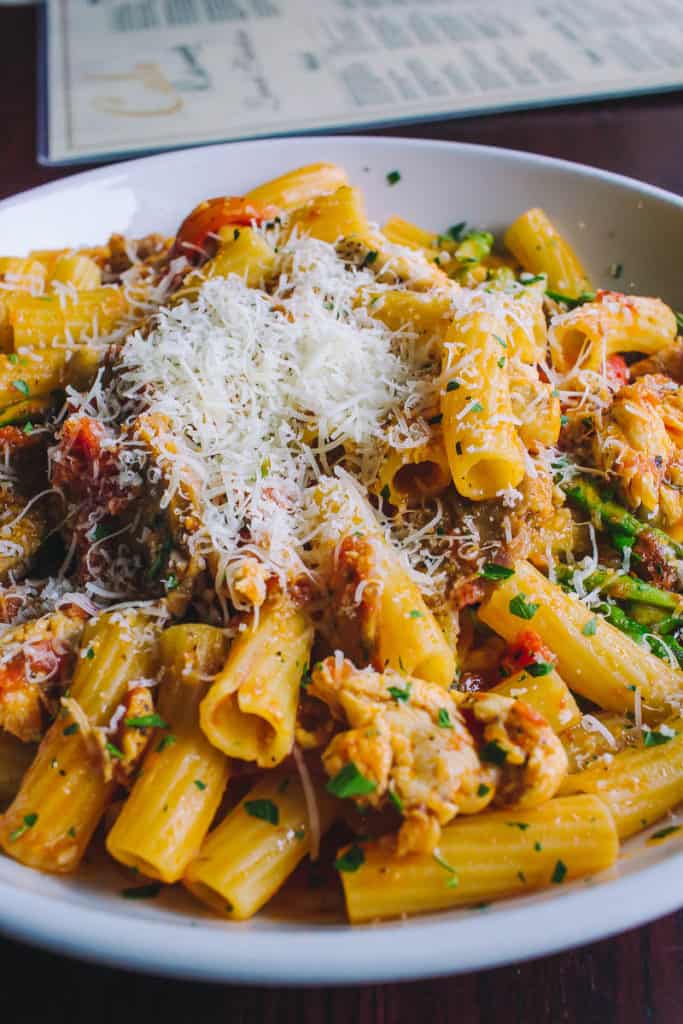 bowl of rigatoni pasta with fresh vegetables and parmesan chese