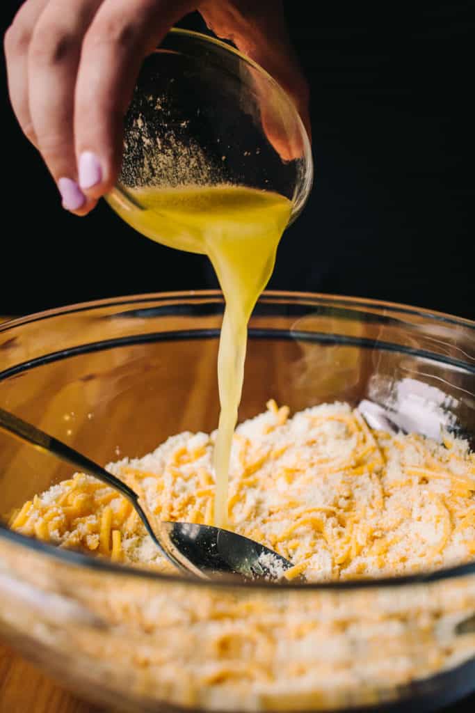 adding melted butter to cheddar biscuit mix
