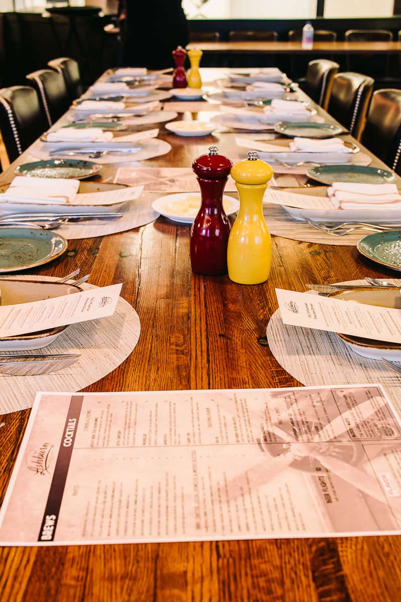 a long table set with plates and menus