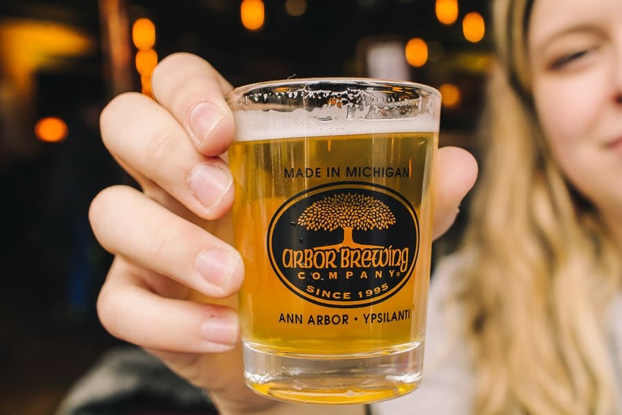 hand held small glass of beer at arbor brewing company