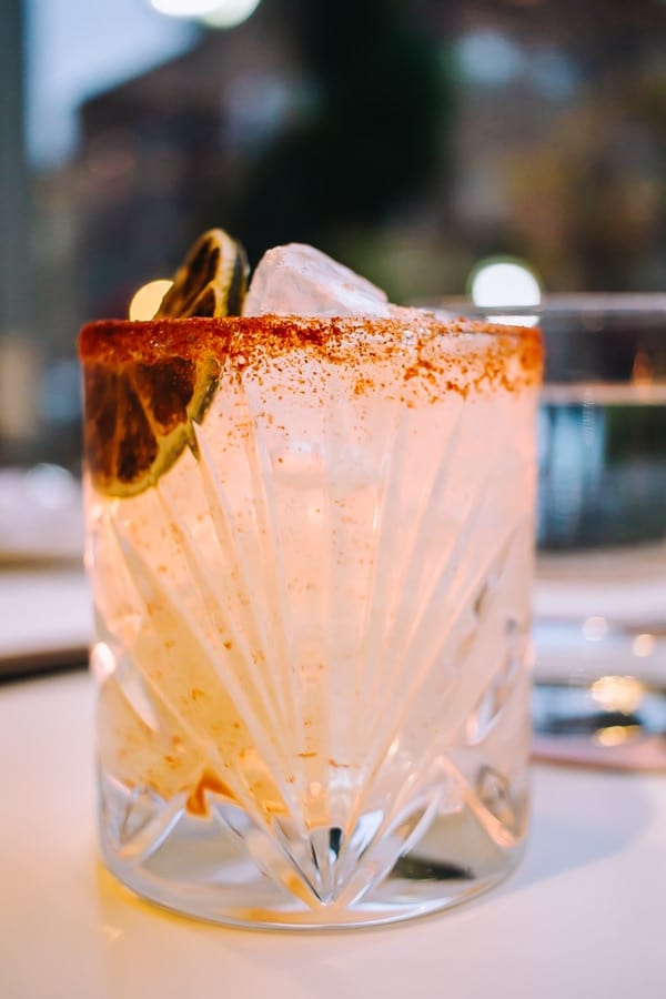 fancy cocktail with a tajin rim and dried citrus to garnish
