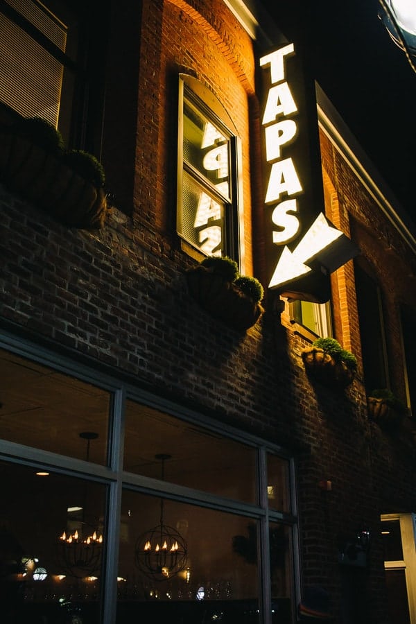 Tapas neon sign with arrow pointing into Aventura restaurant