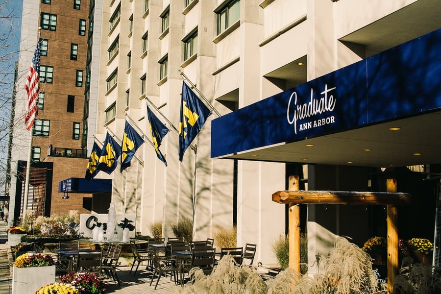 out front of the graduate ann arbor hotel with university of michigan flags flying 