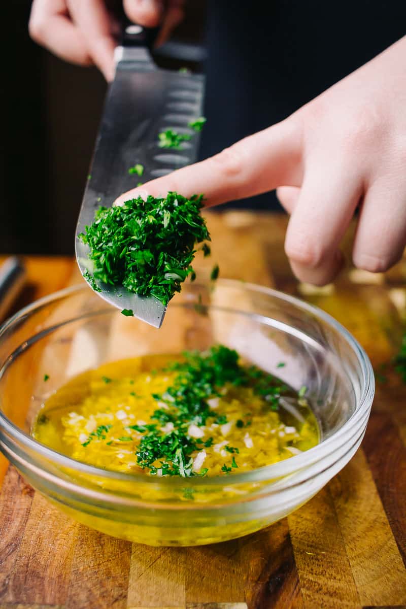 adding parsley to a citrus dressing