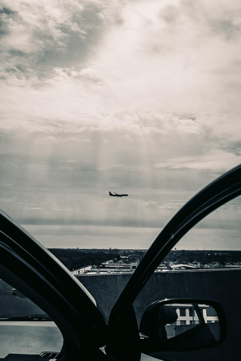 watching a plane landing at the o'hare airport from the room top of a parking garage