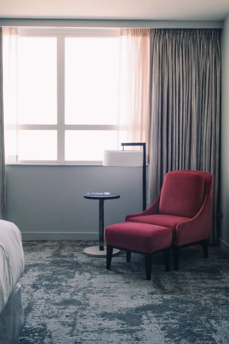 grey hotel room with a red chair at the loews chicago o'hare hotel