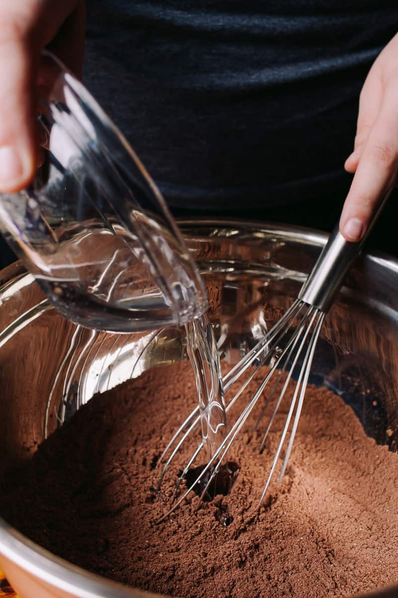 Pouring coconut oil in chocolate batter