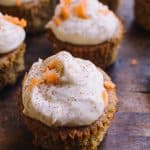 closeup of Low Carb Carrot Cake Cupcakes on a brown chopping block