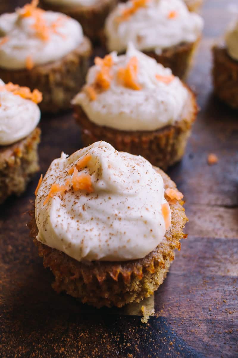 closeup of Low Carb Carrot Cake Cupcakes on a brown chopping block