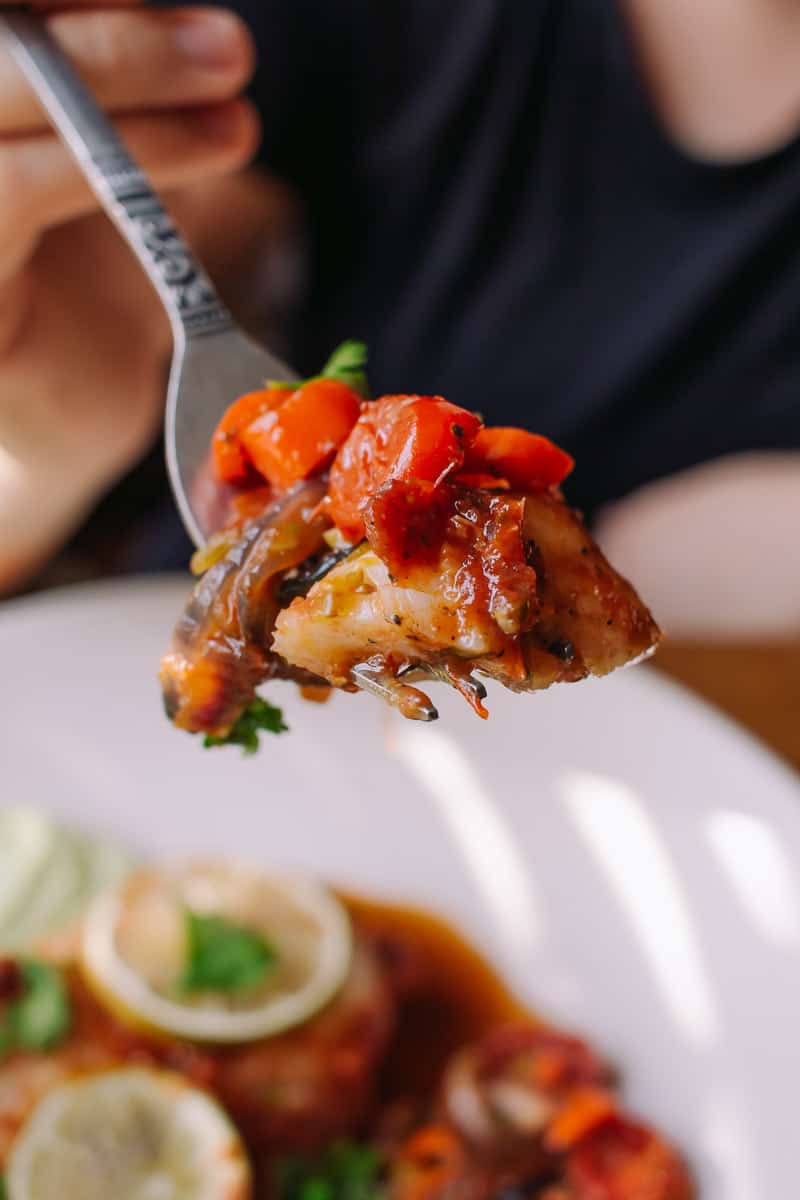 forkful of cod fish with tomatoes