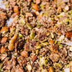 closeup shot of nuts and seeds baked together like trail mix on parchment paper