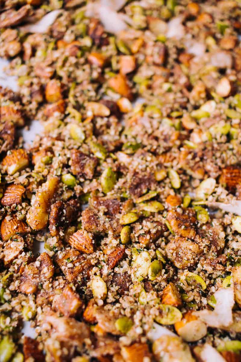 closeup shot of nuts and seeds baked together like trail mix on parchment paper