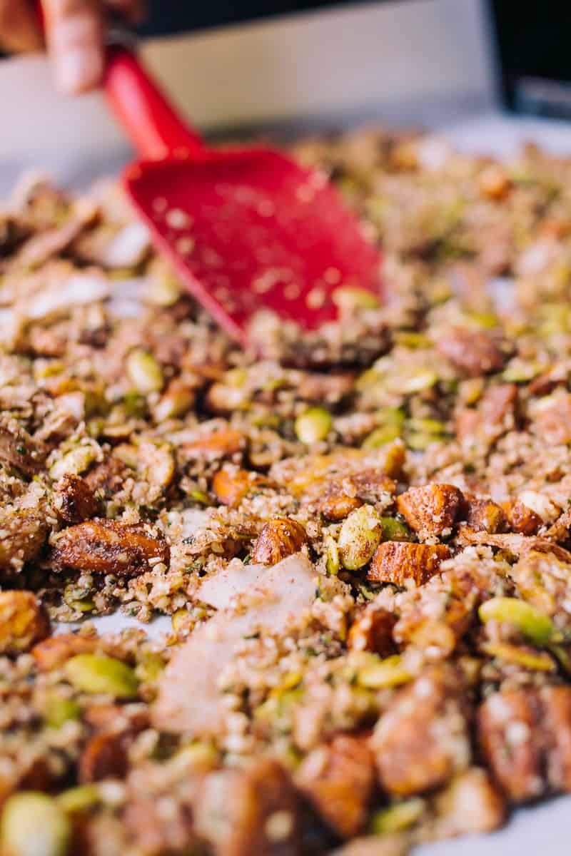 trail mix with a red spatula on a baking sheet