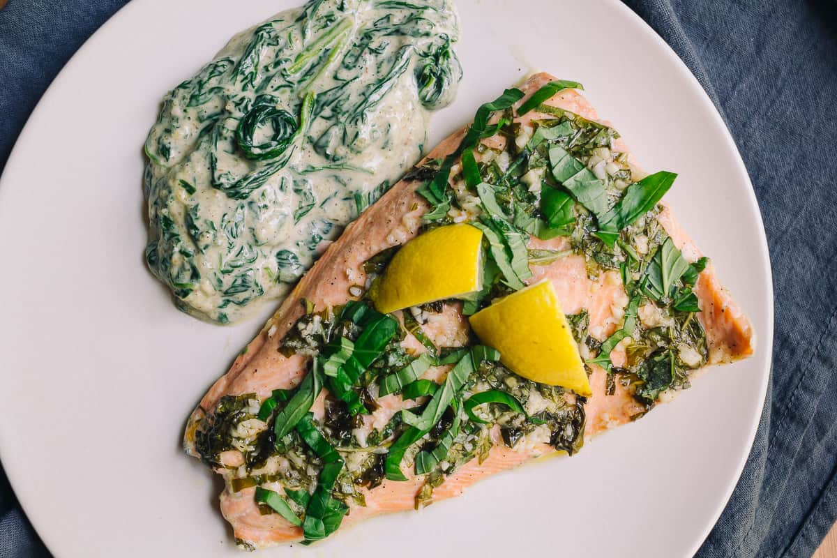 flat lay photo of basil and lemon baked salmon with a side of creamed spinach