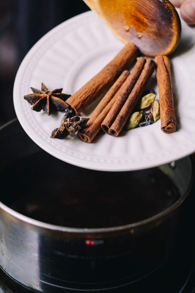 Adding cinnamon to pot of tea