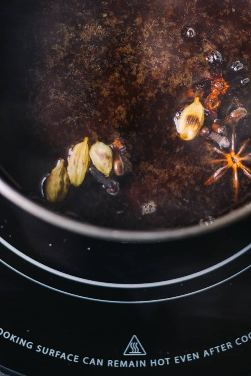 Chai Tea Simmering with warming fall spices like star anise and cardamom pods 