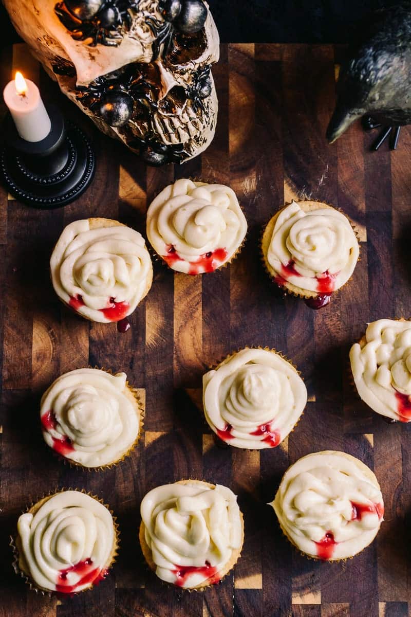 overhead shot, vanilla cupcake with cream cheese frosting and raspberry blood with skull