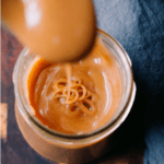 closeup shot of keto salted caramel sauce in a jar dripping from a spoon