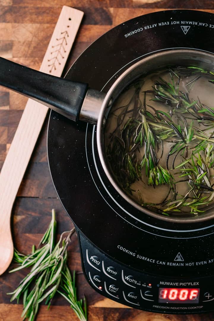 making rosemary simple syrup in a sauce pan with water