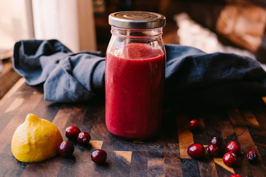 Sugar Free Cranberry Lemon Vinaigrette on a cutting board with a blue grey napkin