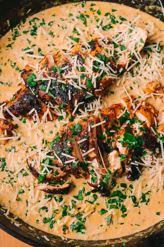 creamy cajun chicken alfredo in a cast iron skillet