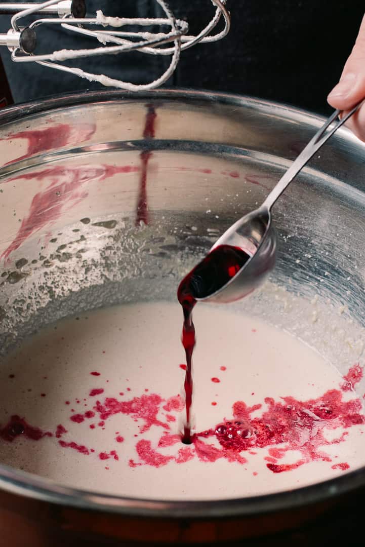 adding bright pink hibiscus concentrate to cake batter