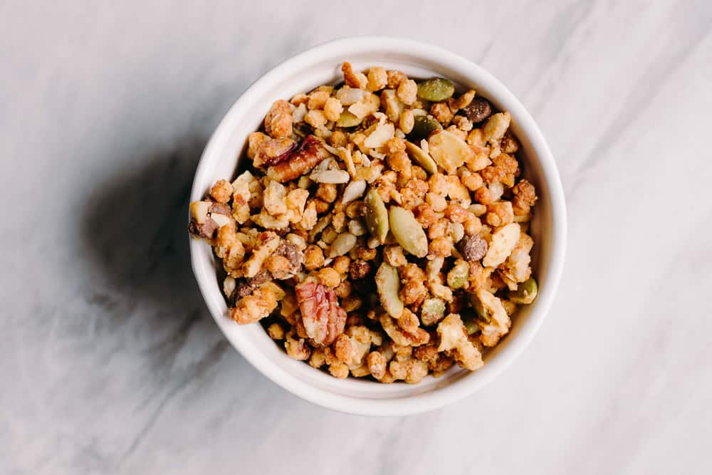 white ramekin on a grey tile with low carb maple granola