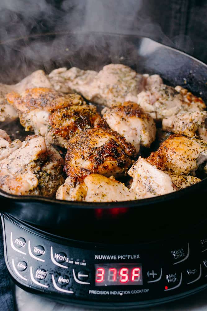 chicken thighs searing in a pan