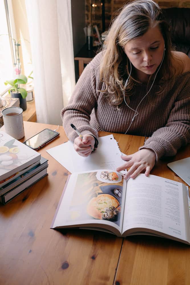 reading a cookbook and writing down ideas