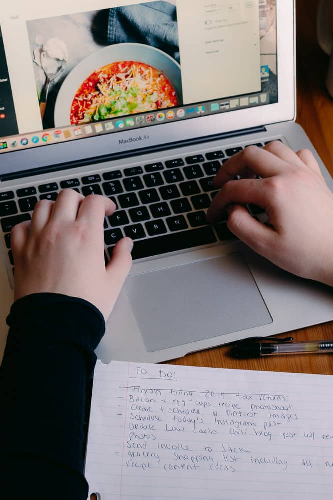 hands typing on a keyboard editing a blog post