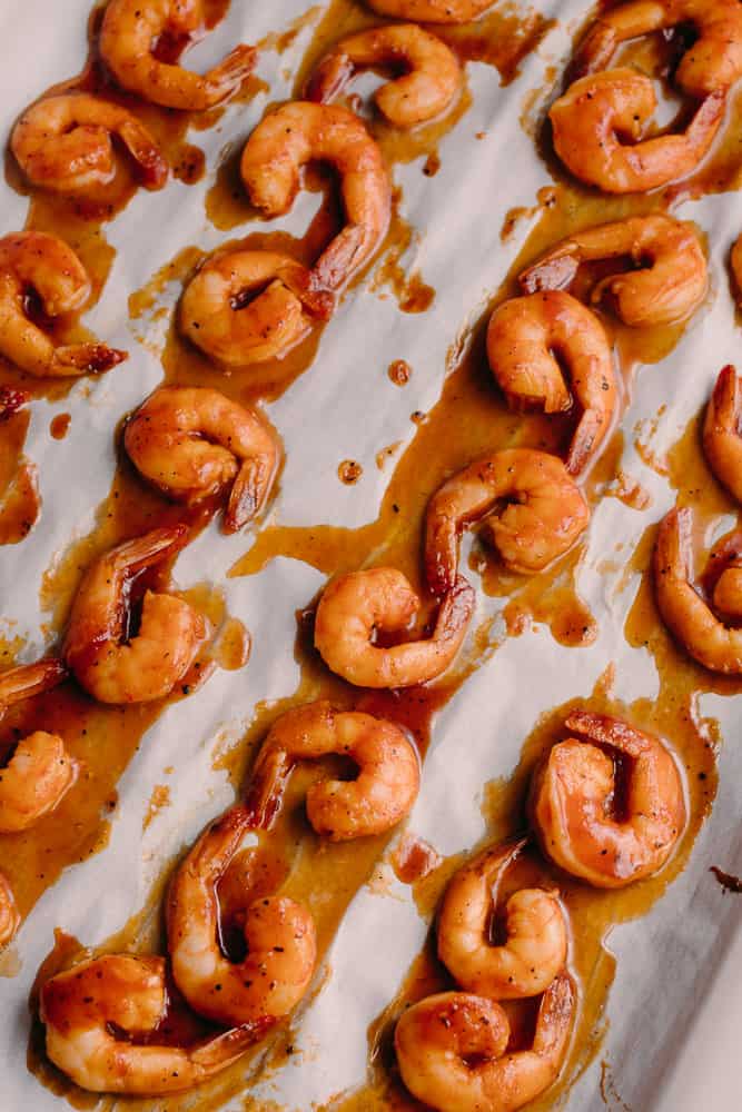 baked shrimp with bbq glaze on white parchment paper 