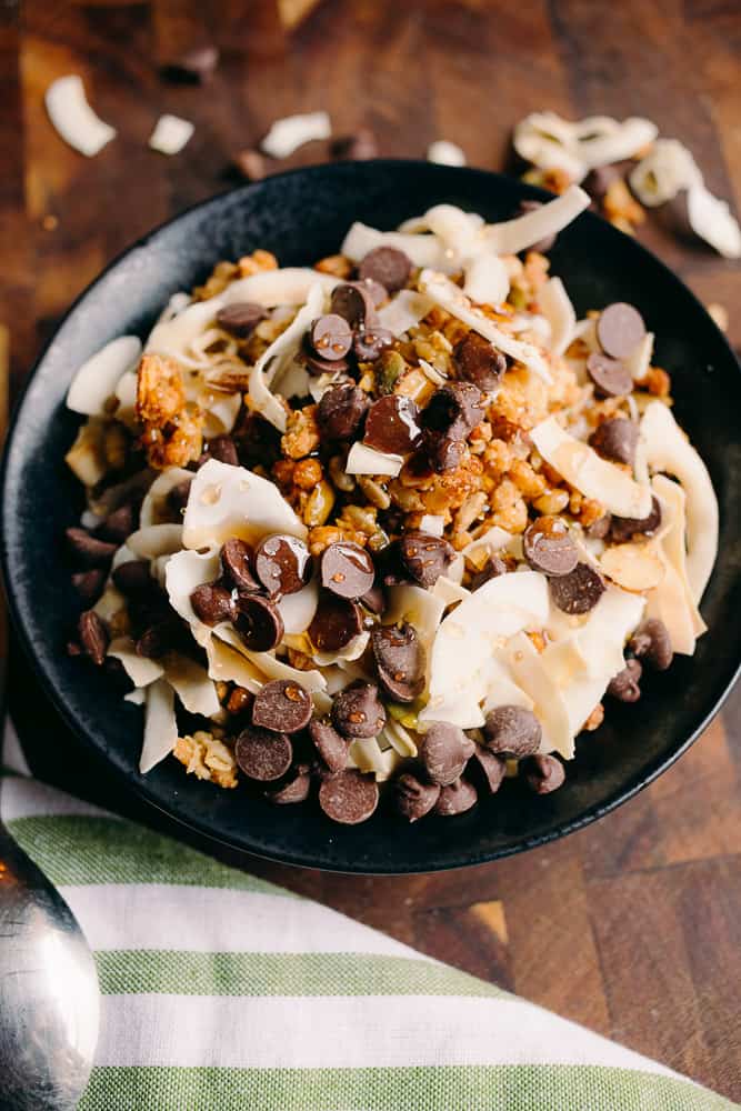 black bowl of maple chocolate granola with a green and white napkin in the foreground