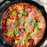 lodge cast iron skllet with baked pepperonis and cheese like a pizza with basil