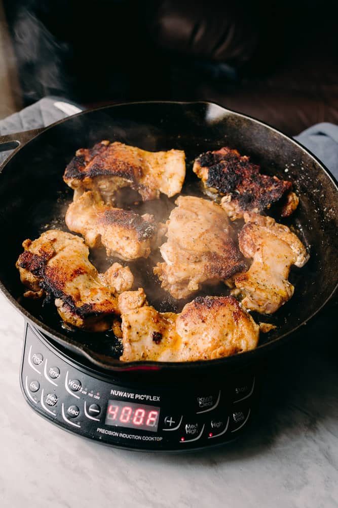 seared chicken thighs in a cast iron skillet