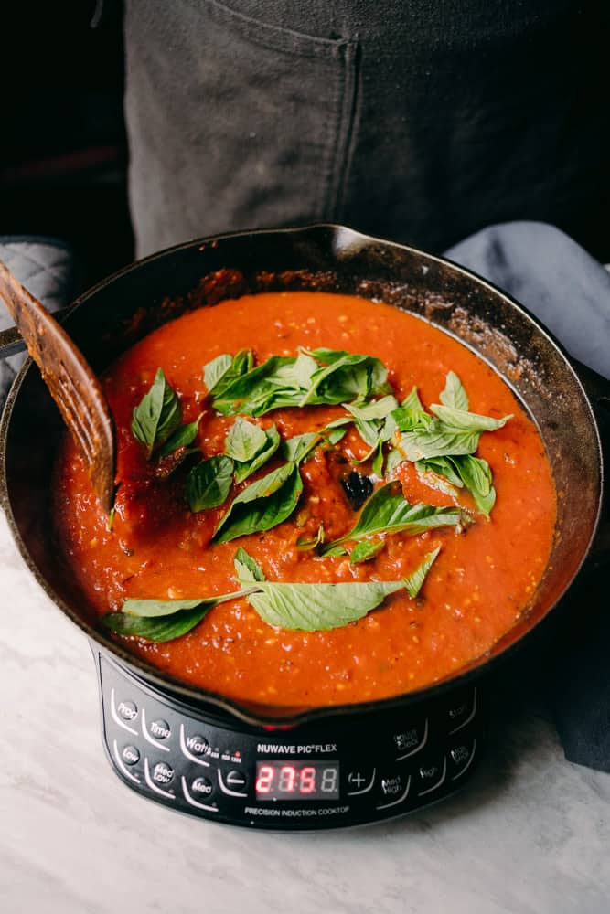 fresh basil in a tomato sauce in a cast iron skillet