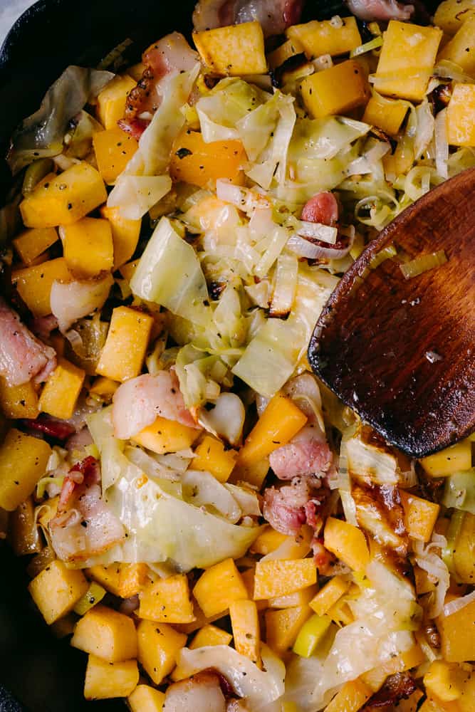 mixing up the cabbage and rutabaga hash with a wooden spoon