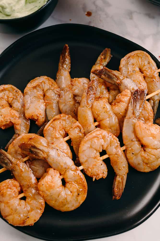 chipotle lime shrimp raw on skewers on a black plate