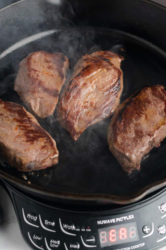 cooking sirloin steaks in a cast iron skillet