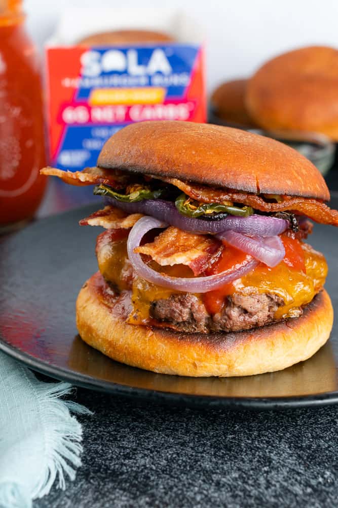 Keto cheeseburger with bbq sauce and bacon made with a sola company burger bun