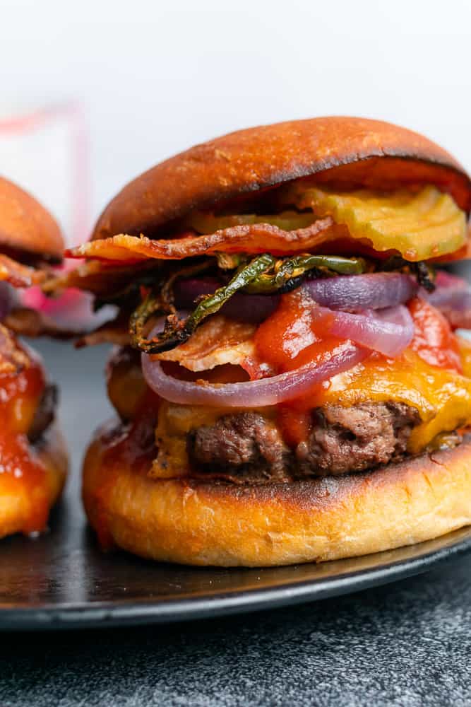 closeup shot of a bbq bacon cheeseburger with jalapeños