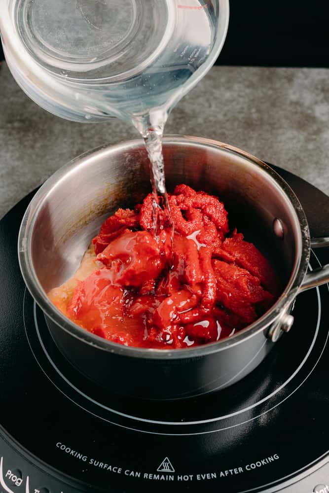 adding water to tomato paste