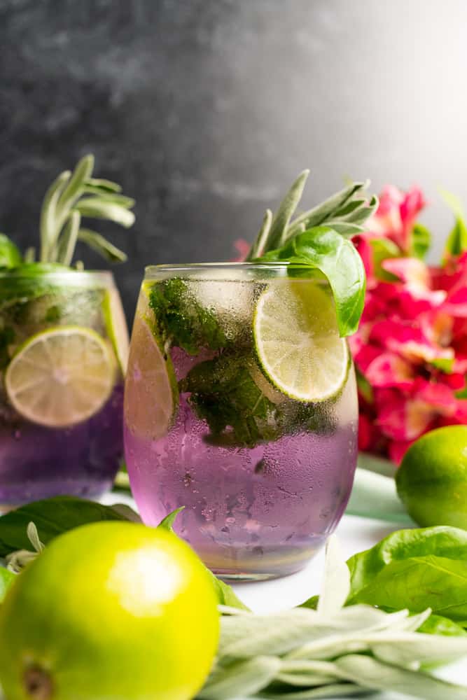 beautiful purple cocktail with limes and pink flowers