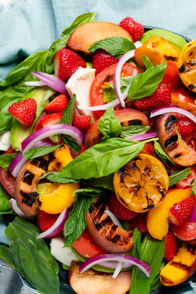 gorgeous summer fruit salad with tomatoes avocado mozzarella peaches strawberries and fresh herbs